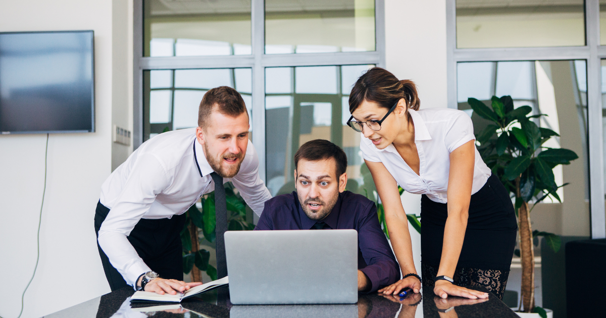 Employees in a modern office using laptops and smartphones connected wirelessly to the network.