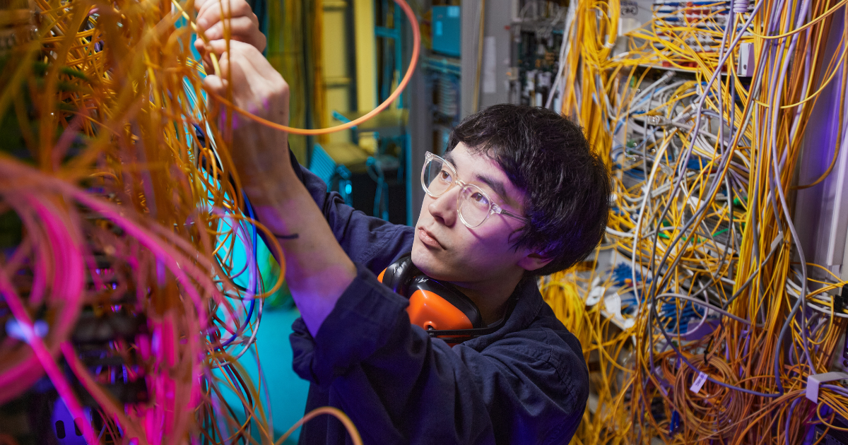 Technician auditing a data cabling system in a server room to identify performance issues.