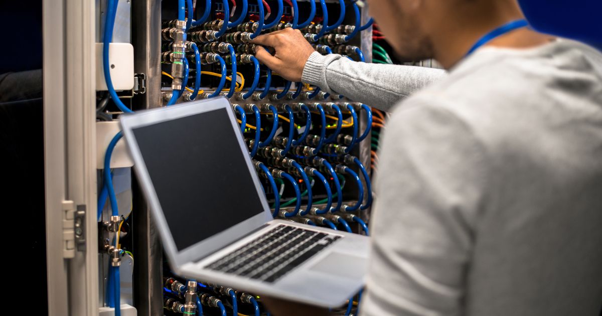 A cabling engineer setting up a server cabinet.